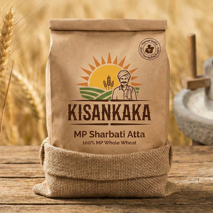 Kisankaka MP Sharbati Atta bag on a wooden surface with wheat in the background